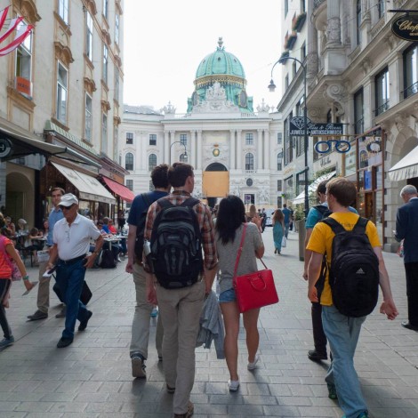 Several students walk past shops as they approach the palace.